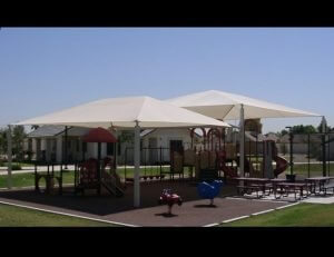 Large tension shade awning with white awning fabric for a playground